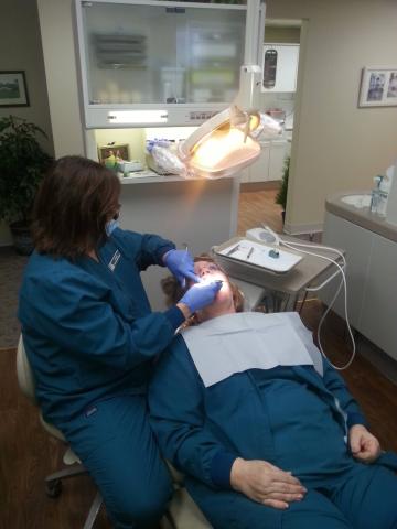 Dentist cleaning patient's teeth