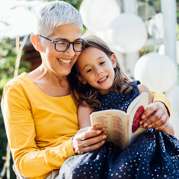 grandmother reading to young granddaughter