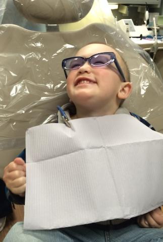 smiling kid sitting on dentist chair